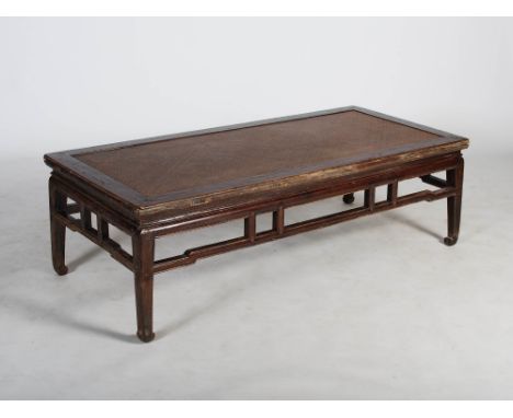 A Chinese dark wood day bed, Qing Dynasty, the rectangular top with woven panel insert above a geometric frieze, raised on fo