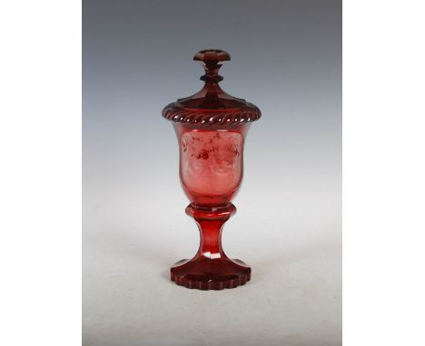 A late 19th century Bohemian ruby flashed goblet and cover, the octagonal shaped bowl decorated with an oval shaped panel of 