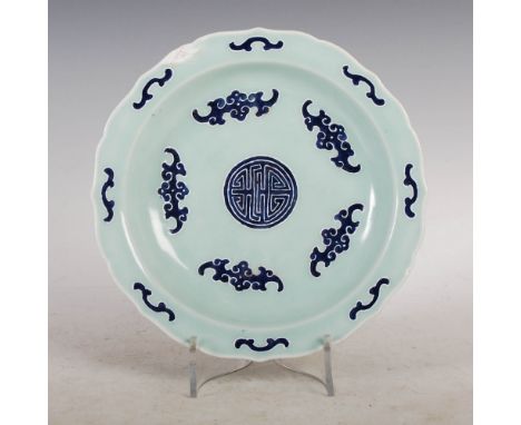 A Chinese porcelain celadon ground dish, Qianlong seal mark and of the period, decorated with a central Shou character surrou