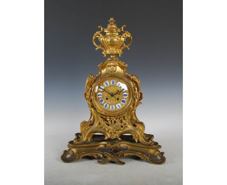 An imposing 19th century French ormolu mantle clock in the Rococo style, the circular dial with enamelled Roman numeral panel