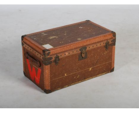 An early 20th century leather and brass bound cabin trunk in the style of Louis Vuitton, with hinged cover and leather strap 