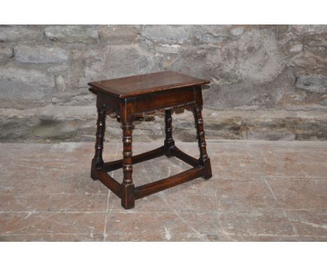 An 18th century oak joynt/ joint stool, the planked rectangular top with a moulded edge above a plain frieze, raised on four 