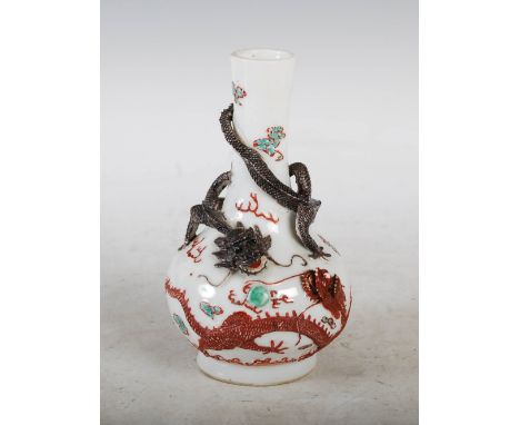 A small Chinese porcelain bottle vase, decorated in relief with two dragons contesting a flaming pearl, 15cm high.