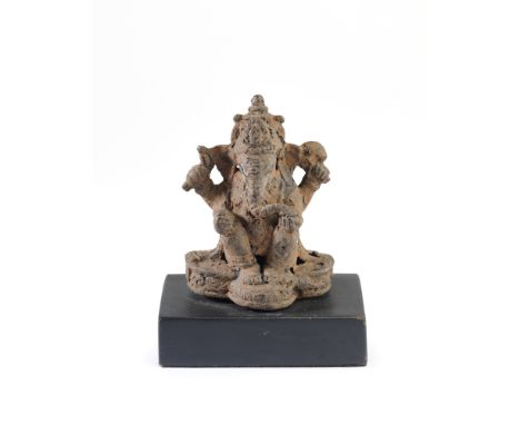 A MAHAPAHIT IRON FIGURE OF GANESHA, JAVA, 14TH CENTURY the four-armed elephant headed deity seated on a lobed plinth, holding
