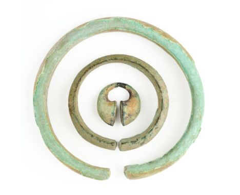 THREE ITEMS OF ANCIENT BRONZE JEWELLERY, PROBABLY JAVA, 9TH/10TH CENTURY comprising a large and a small bracelet and an ear o