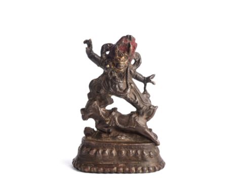 A SMALL TIBETAN BRONZE FIGURE OF YAMA on lotus base, the fiercesome buffalo headed Buddhist deity stepping to his right on a 