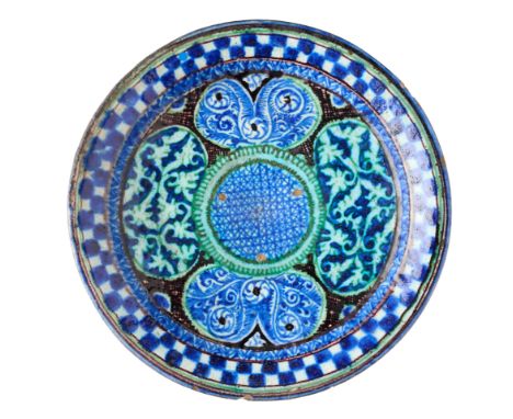 A CENTRAL ASIAN POTTERY DISH, PROBABLY KOKAND, UZBEKISTAN, 19TH CENTURY of shallow form, painted in cobalt, manganese and gre