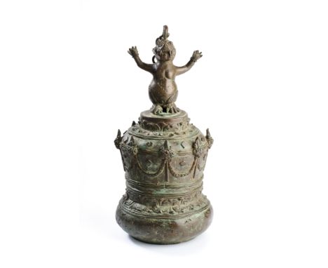 A LARGE BRONZE BELL, JAVA, 20TH CENTURY the sides decorated with lotus motifs and floral swags, the finial in the form of a m