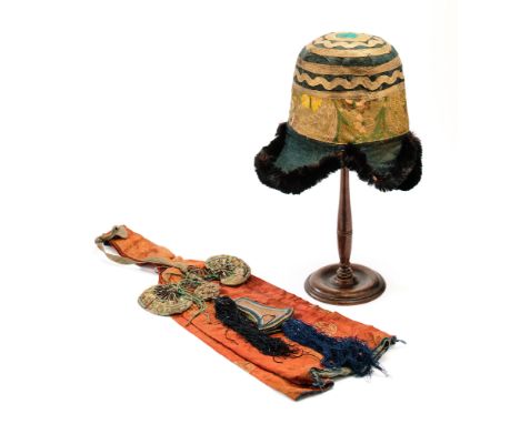 TWO ARTICLES OF HIMALAYAN COSTUME, CIRCA 1900 comprising a Nepalese hat with gilt brocade band and floral decoration on black