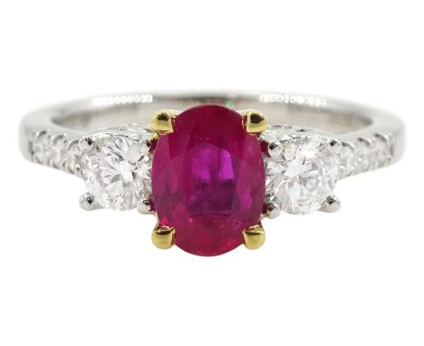 18ct white gold three stone oval ruby and round brilliant cut diamond ring, with diamond set shoulders and gallery, stamped 7