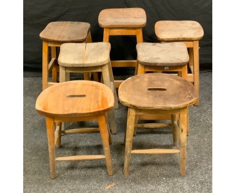 Five elm school stools, saddle seats; another pair shaped seat. (7) 