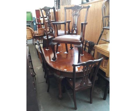 A 1920s oval wind out table with eight Chippendale style chairs. 