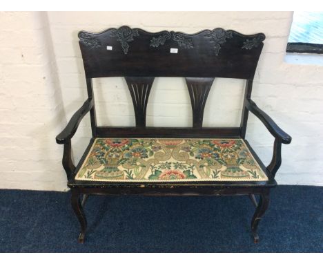 A dark stained mahogany two seater Edwardian bench, with American style back.