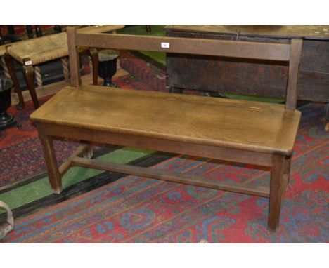 An early 20th century oak hall bench with under seat storage 