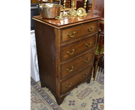 A 20th century tall chest, four long graduated drawers, brass swing handles, bracket feet