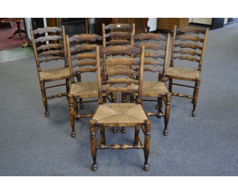 A set of six Titchmarsh and Goodwin style oak rush seated ladder back chairs