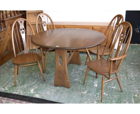 An elm Ercol drop leaf table with two carvers and two dining chairs 