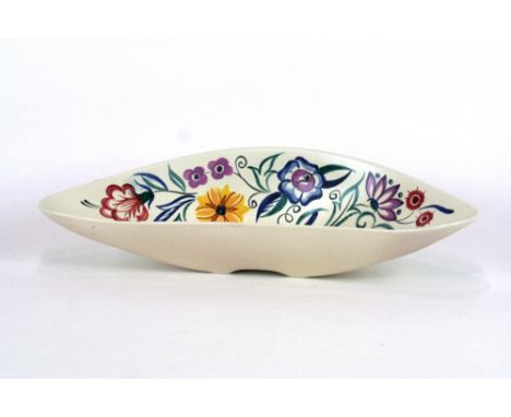 A Poole pottery dish of curved form, typically decorated with colourful flowers on white ground, 45cm in extremes