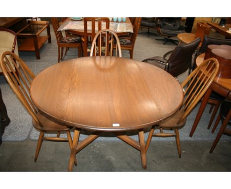 An Ercol drop leaf dining table, 72cm high, 125cm x 113cm extended and a set of four matching stick back chairs