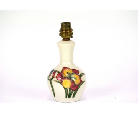 A Moorcroft pottery 'Fresia' table lamp, decorated with tube lined flowers on ivory ground, stamped to base,Moorcroft, Made I