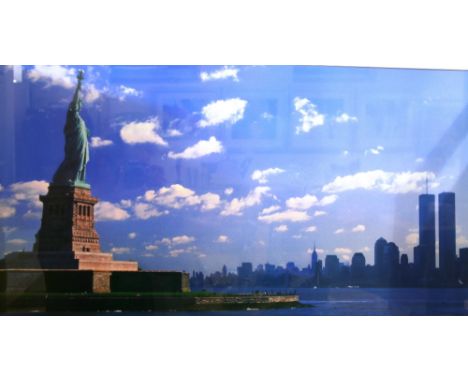 A coloured print depicting the Statue Of Liberty with view of Manhattan in the far ground, 43cm x 79cm