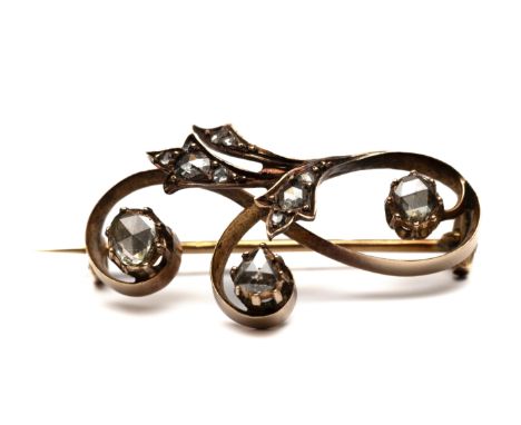 14 kt. Gouden broche, ca. 1900. Met een decor van krullen en bladmotieven. Bezet met roosgeslepen diamant.  bruto 4,1 gr., h.