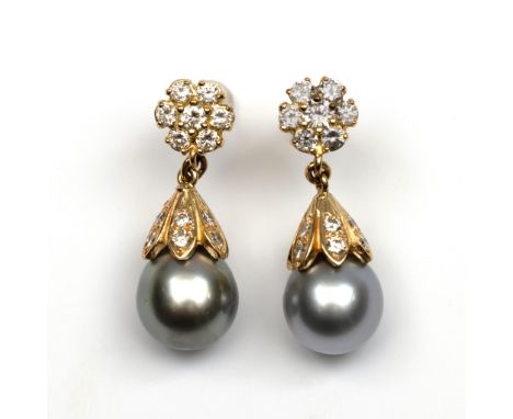 14 kt. gouden oorstekers. Bestaande uit een rozet bezet met briljant geslepen diamant waaronder een druppel, de bovenzijde be