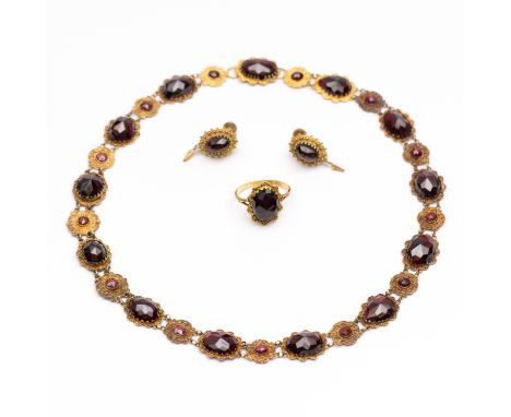 Gouden bootjesketting, ca. 1900. De schakels om en om ovaal en rond, bezet met granaat en gedecoreerd met filigrain. Hierbij 
