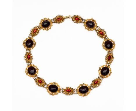 18 kt. Gouden bootjescollier, opgebouwd uit opengewerkte ovale schakels bezet met rood en wit paste (twee schakels bezet met 