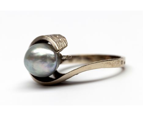 14 kt. Witgouden ring, jaren '70. In de vorm van een krul met gearceerde zijkant, bezet met een lichtgrijze barokparel (ca. 1