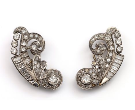 14 kt. Witgouden asymmetrische oorstekers, jaren '50. Met een decor van krullen, bezet met (oud) briljant, achtkant en baguet