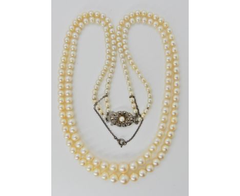 A double string of cream tapered pearls with good lustre and a silver clasp, largest pearl approx 7.1mm smallest pearl 3.4mm 