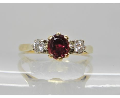 An 18ct ruby and diamond three stone ring, dimensions 5mm x 4.5mm x 3.1mm, diamonds estimated approx combined 0.12cts, size P