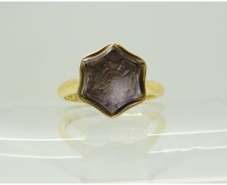 An 18ct gold intaglio engraved amethyst signet ring, carved with a Knights cross, hallmarked Birmingham 1920-21, finger size 