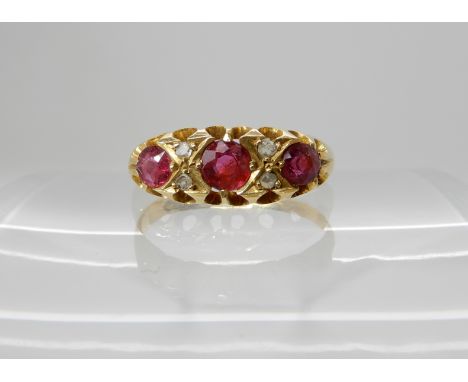 An 18ct gold ruby and diamond ring size N, largest ruby approx 4mm, smallest 3.4mm, diamonds rose cuts, weight 2.5gms Conditi