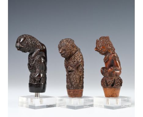 North-Java, three wooden kris hilts, consisting of a crouching ancestor figure wearing ornaments, a crouching demon figure wi