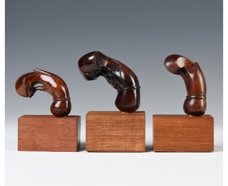 Sulawesi, Salayer, three wooden kris handles, one item with a flower heart at the centre, all three with sprouting fern tops.