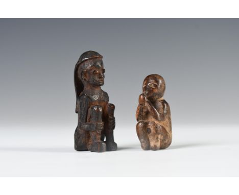 Borneo, East-Kalimantan, Dayak two wooden amulets, the first item depicts a crouching figure with long hair, the hands holdin