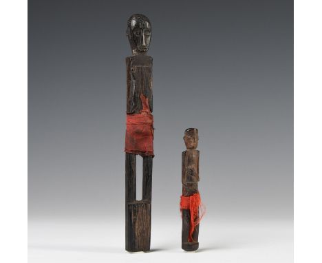 Borneo, East-Kalimantan, two Luangan Dayak amulets, the figures both in standing position and dressed in a red loincloth. H. 