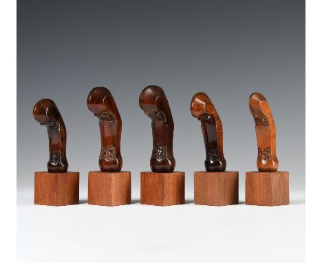 Java, Surakarta, five wooden kris hilts, all shaped as young shoots from a tree trunk; two showing Javanese characters at the