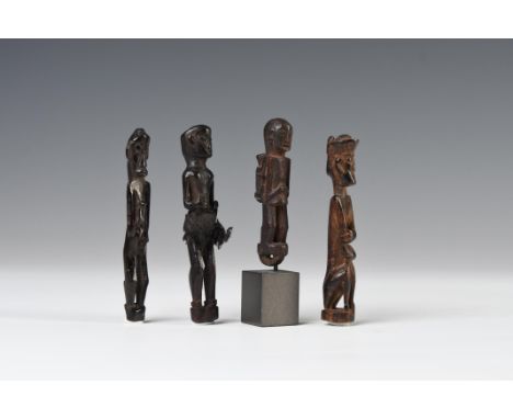 Borneo, East-Kalimantan, four wooden amulets, three in standing position, one squatting, one amulet being a pendant shows a m