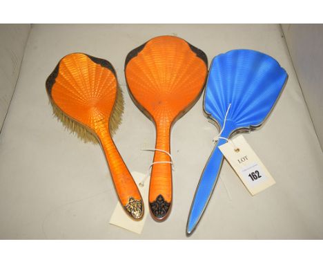 A silver and blue enamel dressing mirror; and a plated and orange enamel part dressing set.  (3)