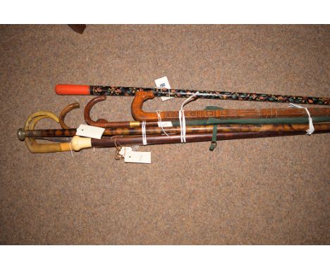 A 19th Century rosewood and bone finial walking cane; other walking canes and a leather handles umbrella.