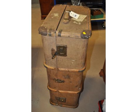 An early 20th Century canvas travelling trunk with brass, leather and wooden mounts.
