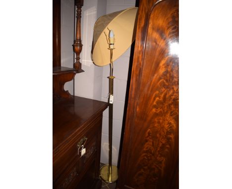 A modern brass standard lamp with cream shade.