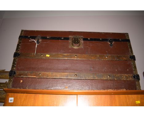 An early 20th Century travelling trunk with domed cover wood and metal bindings.