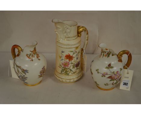 Royal Worcester: a blush ivory ewer with mask and flower decoration no. 1566, initialled 'LD'; and a pair of flatback jugs no