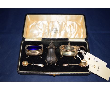 A three-piece silver condiment set, by Northern Goldsmiths, Birmingham 1938, with spoons, in fitted case; together with a gar