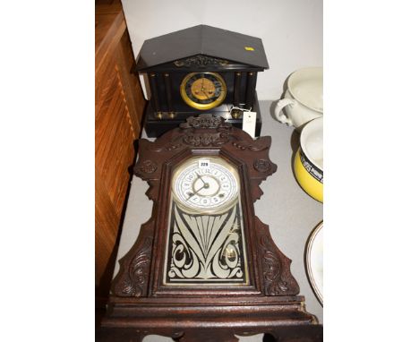 A black marble mantle clock with roman numberal dial; together with a wooden wall clock, acanthus leaf decoration.  (2)