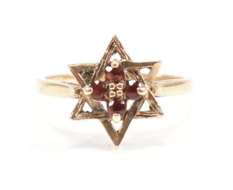 A hallmarked 9ct gold garnet star cluster ring. 2.3g. Size M.5. All weights, measurements and sizes are approximate&nbsp;